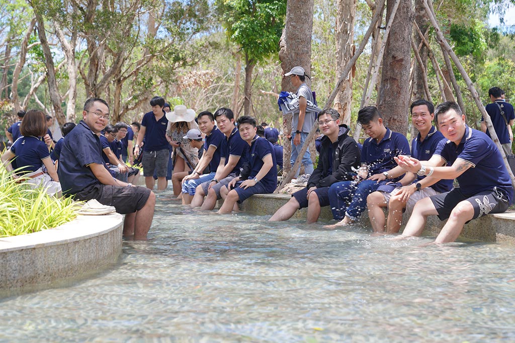 A group of people sitting on a rock in a river

Description automatically generated with low confidence